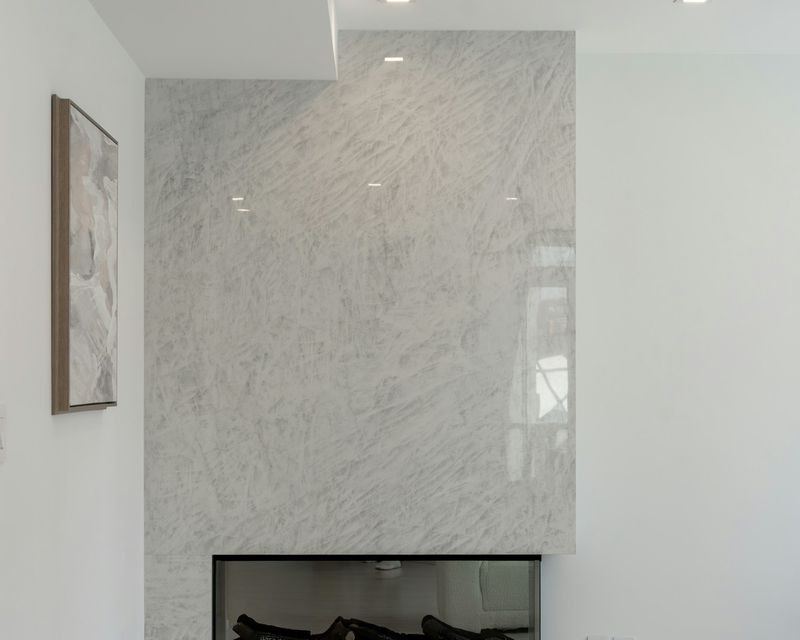 Fireplace clad in white marble in a minimal living room