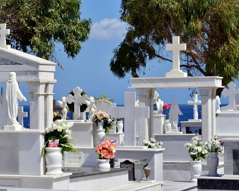 Row of white marble graves with fresh flowers