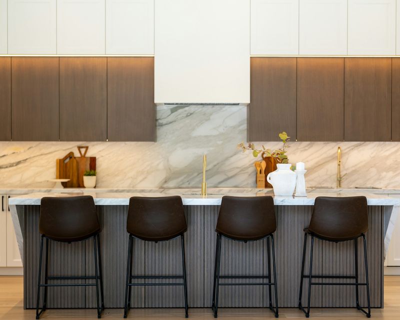Marble kitchen island with bar stools and a matching splashback