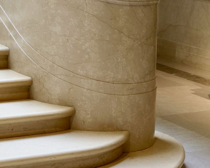 Curved staircase in warm beige marble